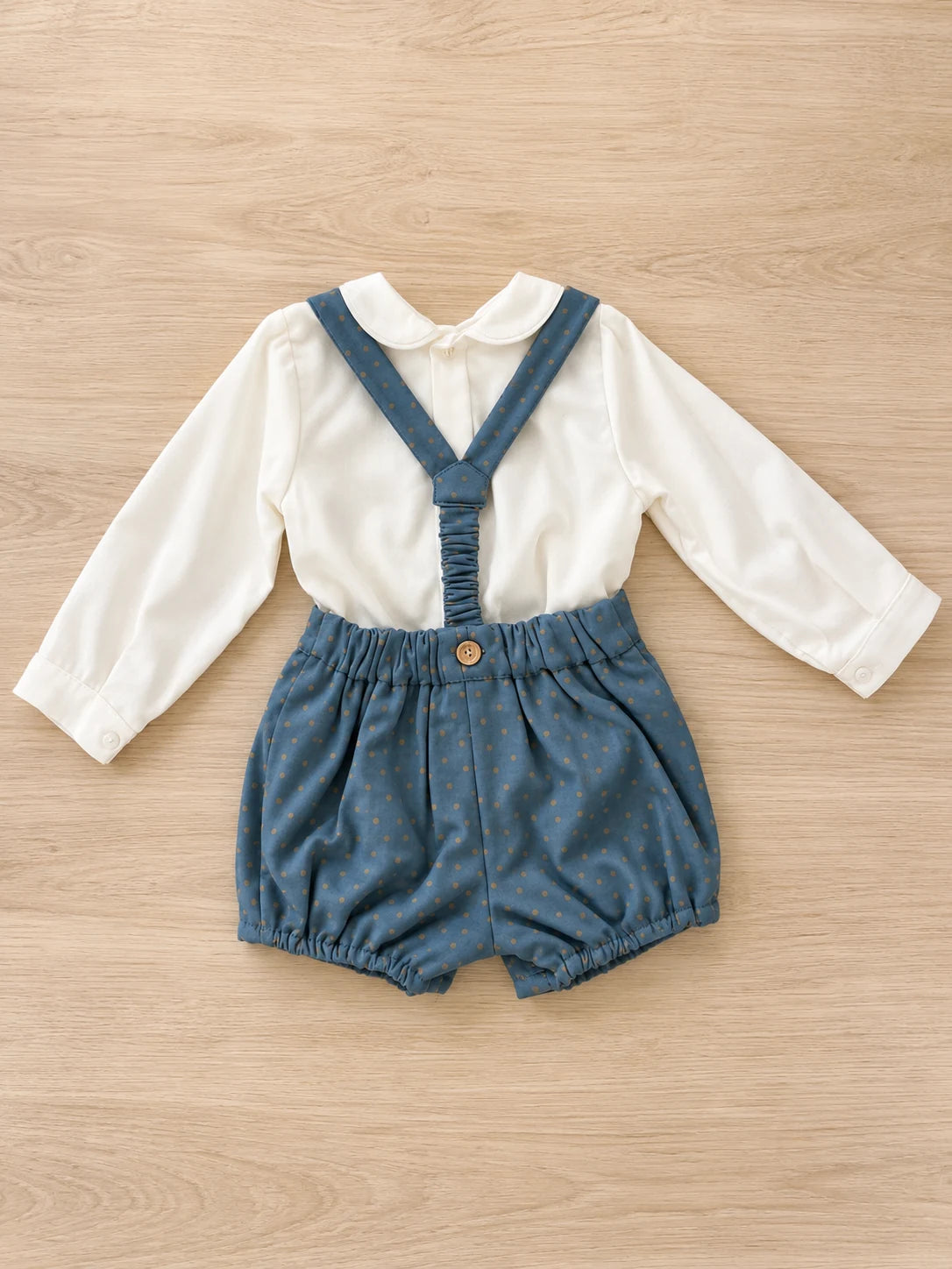 Trasera de conjunto niño azul petróleo y topos beige, con tirantes