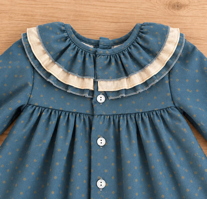 Detalle de cuello con doble volante beige de vestido de niña azul petróleo